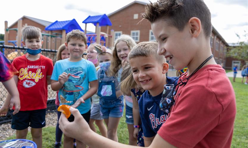 Students smile while releasing butterflies outside
